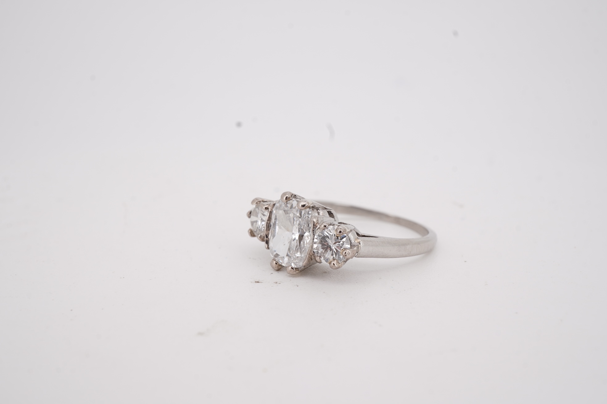 A diamond ring, set with a cushion-shaped diamond weighing 1.50 carats, between shoulders set with brilliant-cut diamonds totalling approximately 0.40 carats, size K, gross weight approximately 4 grams, Condition: centra